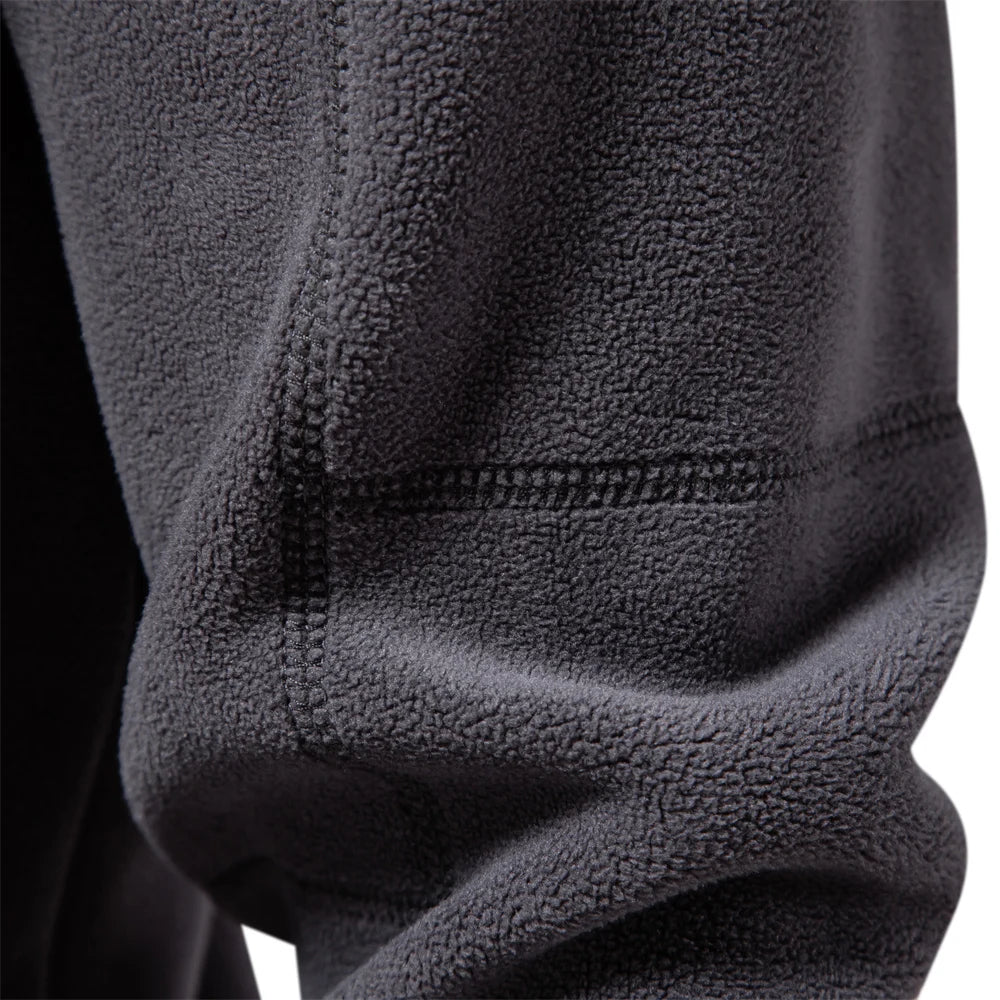 Close-up of a textured black fleece fabric with a zipper.