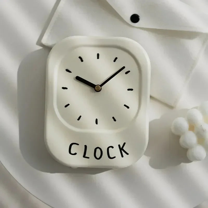 White wall clock with 'CLOCK' text on a light background