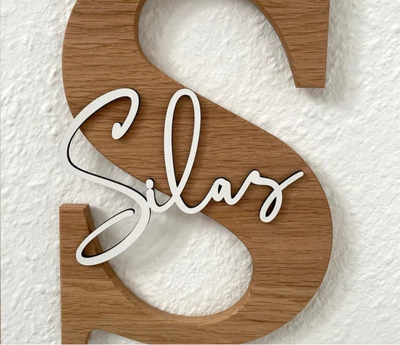 Wooden letter 'S' with 'Silas' engraved on a textured white background