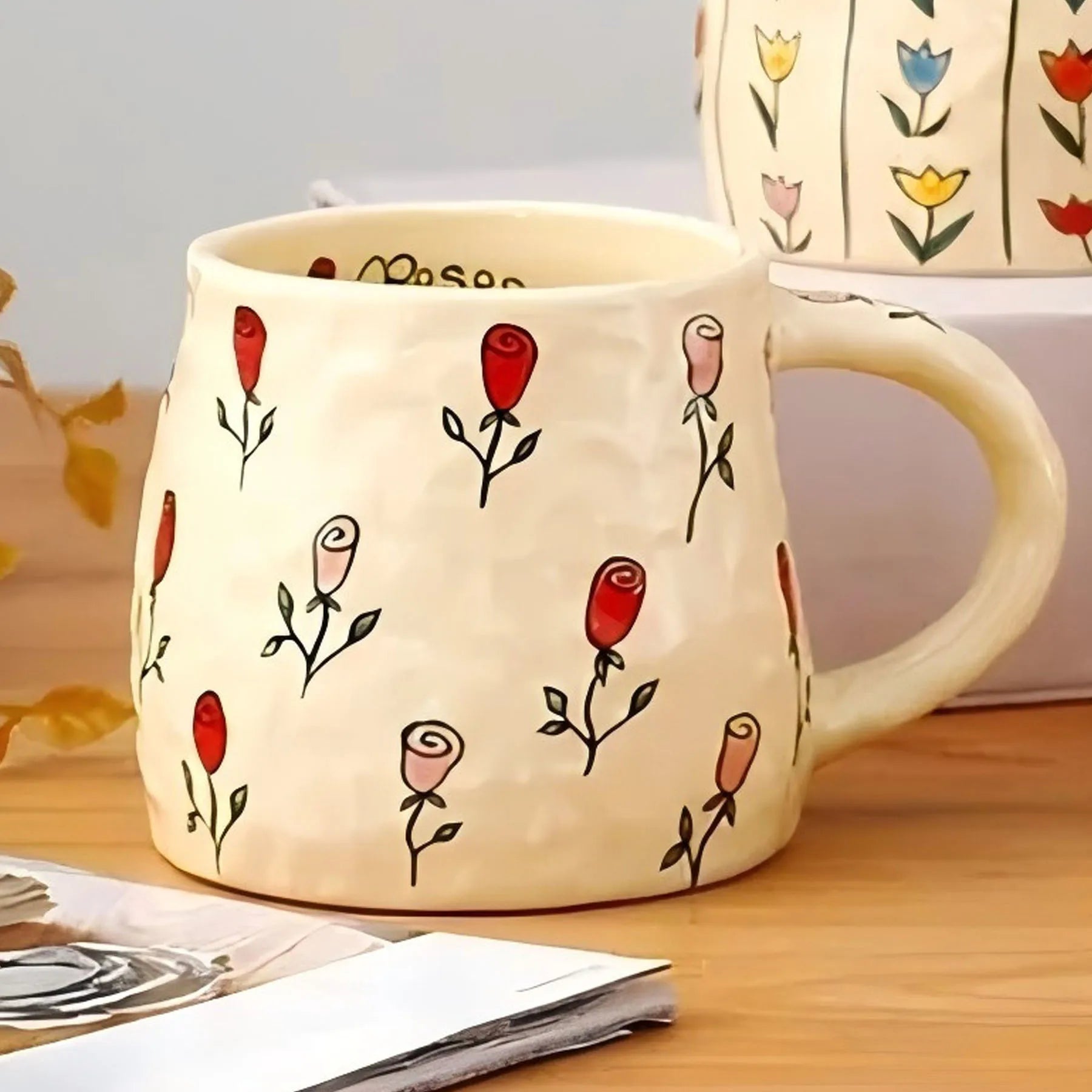 Ceramic mug with floral designs on a wooden surface