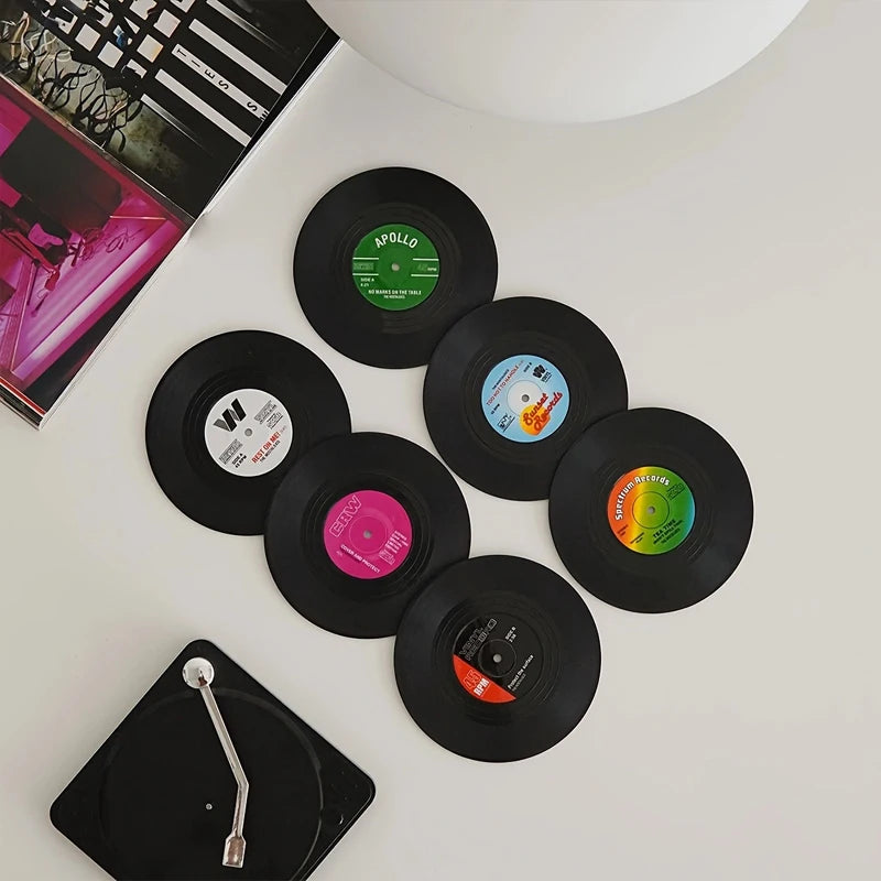 Collection of vinyl coasters with colorful labels on a white surface