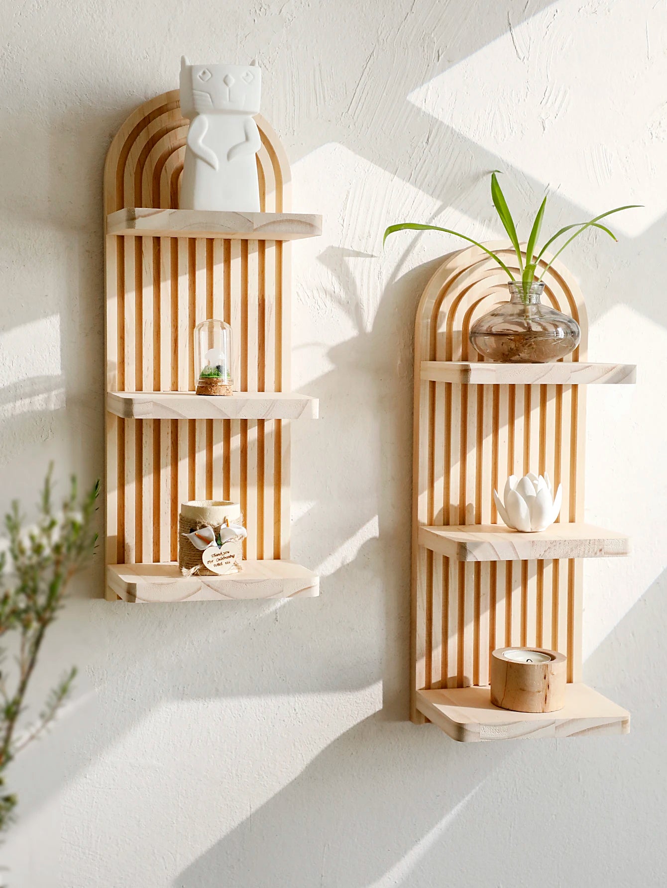 Two wooden wall shelves with decorative items against a white wall.