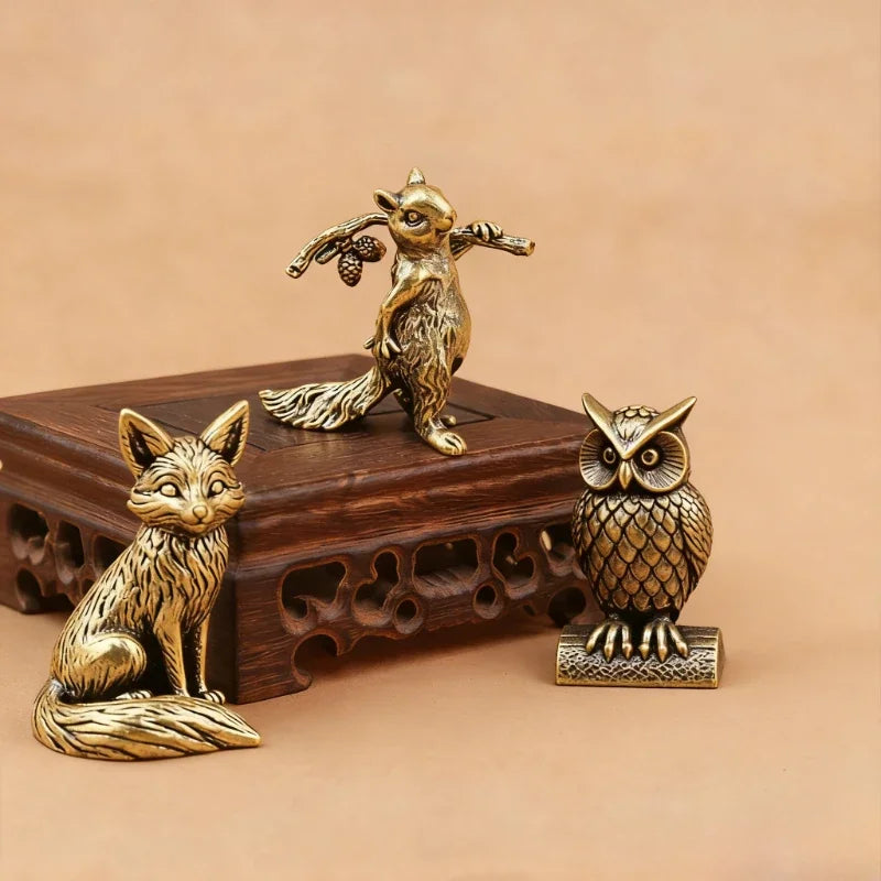 Small brass animal ornament figurines with detailed finish placed on a desk as decorative accent