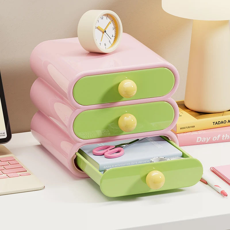 Pastel pink and green desk organizer with clock on a desk.