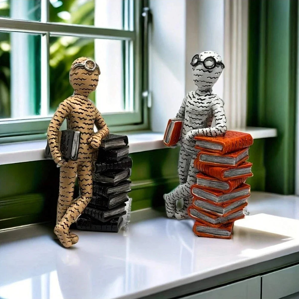 Minimalist resin reader statue leaning against a stack of books displayed on a windowsill in a modern home.