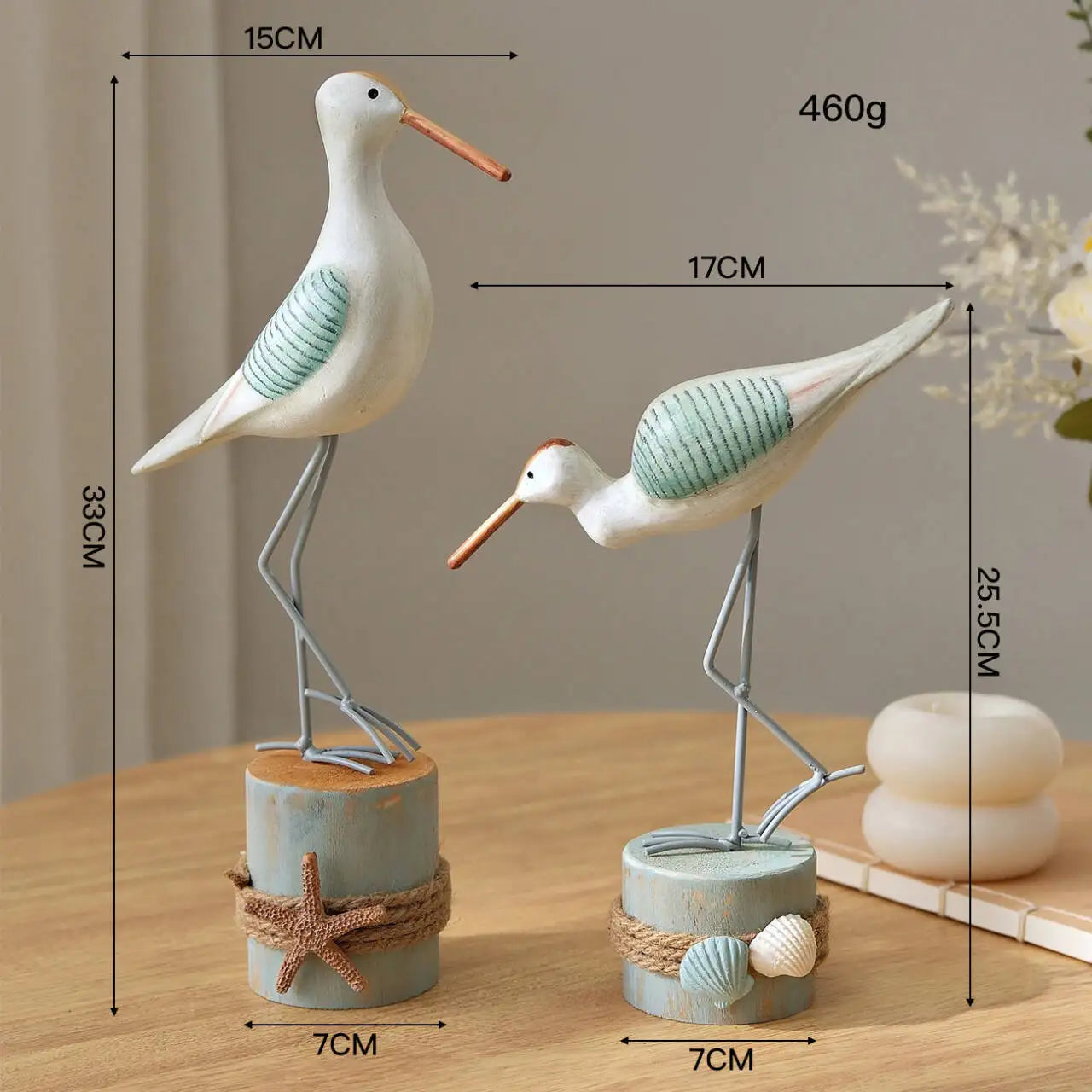 Two decorative bird figures with measurements on a wooden surface.