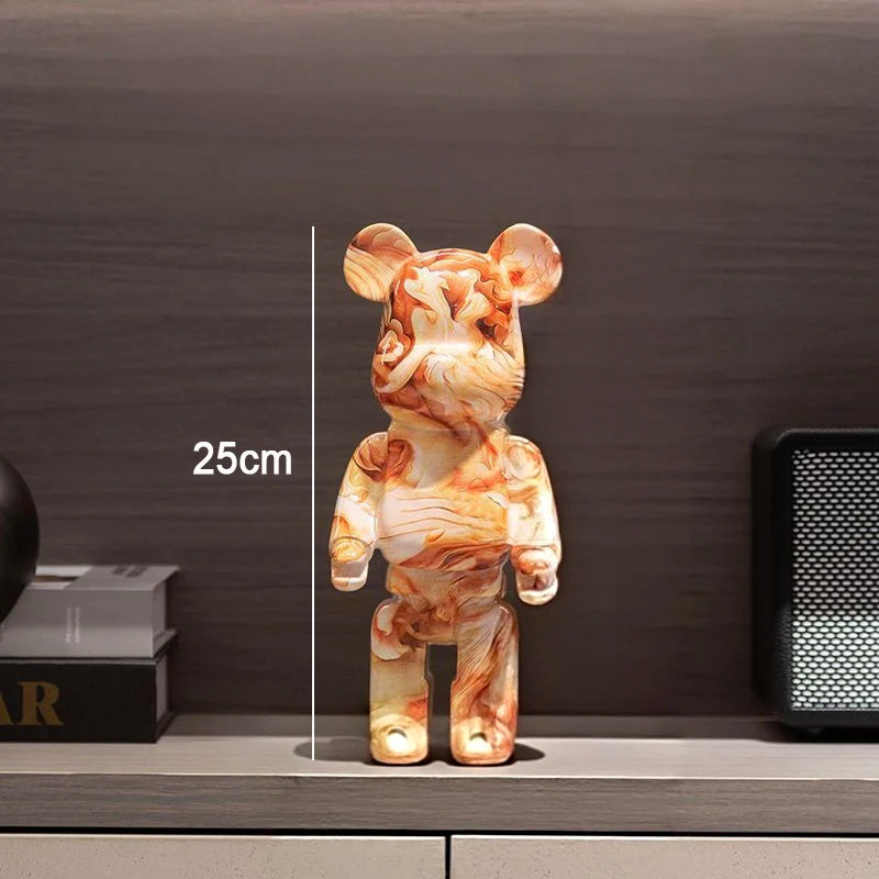 A 25cm tall bear-shaped collectible figurine with a marbled orange, beige, and white pattern, standing on a shelf against a dark wood background.
