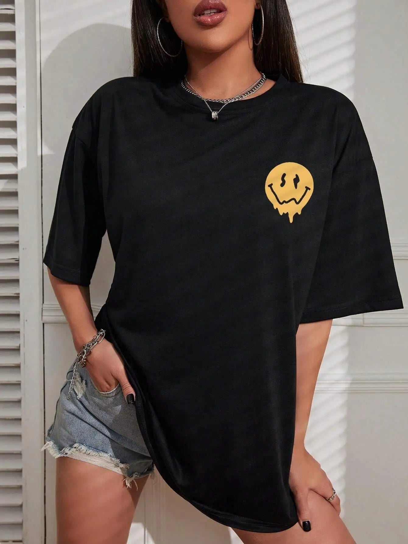 Person wearing a black t-shirt with a yellow smiley face design.