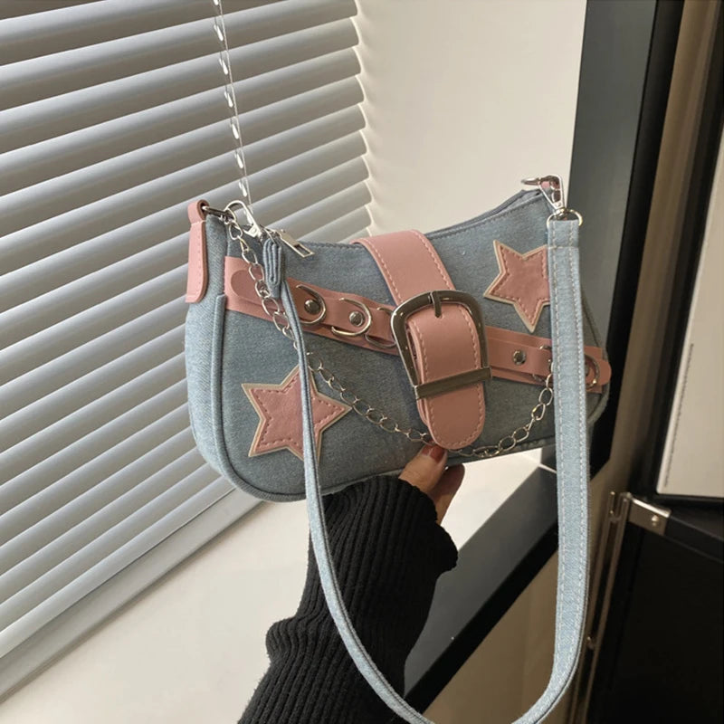 Handbag with star designs held by a person in front of a window with blinds.