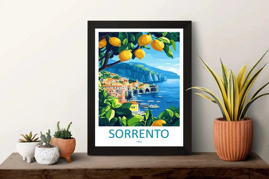 Framed artwork of Sorrento with lemons and a scenic view, displayed on a shelf with plants.