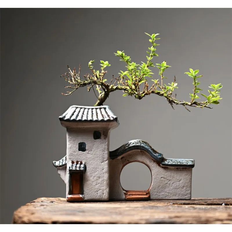 Small architectural model with a tree on top against a gray background