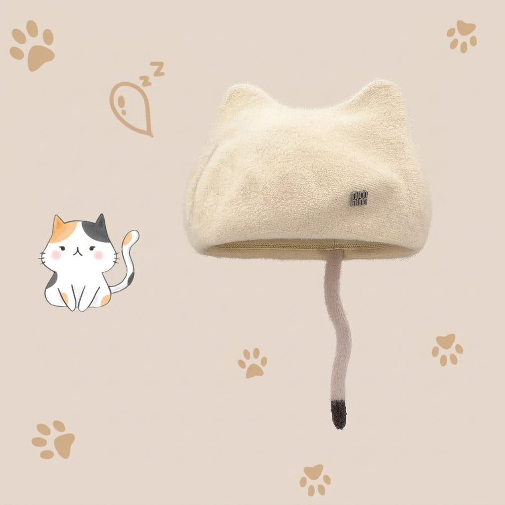 A cream-colored plush cat-earhat with a long faux-fur tail and a small black brand tag, shown on a beige background with paw-print graphics.