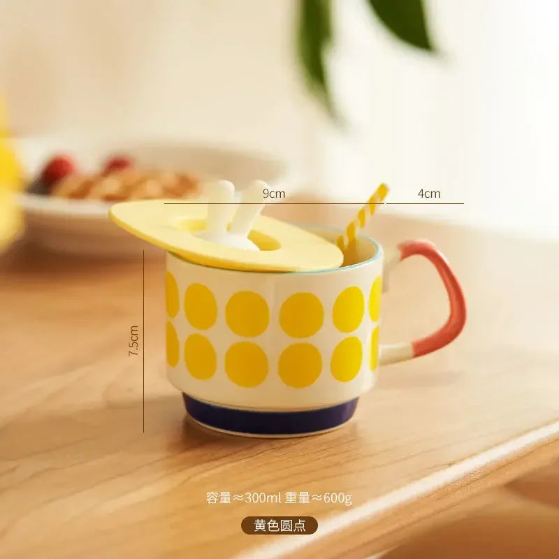 Yellow polka dot mug with red handle on a wooden surface, measurements shown.