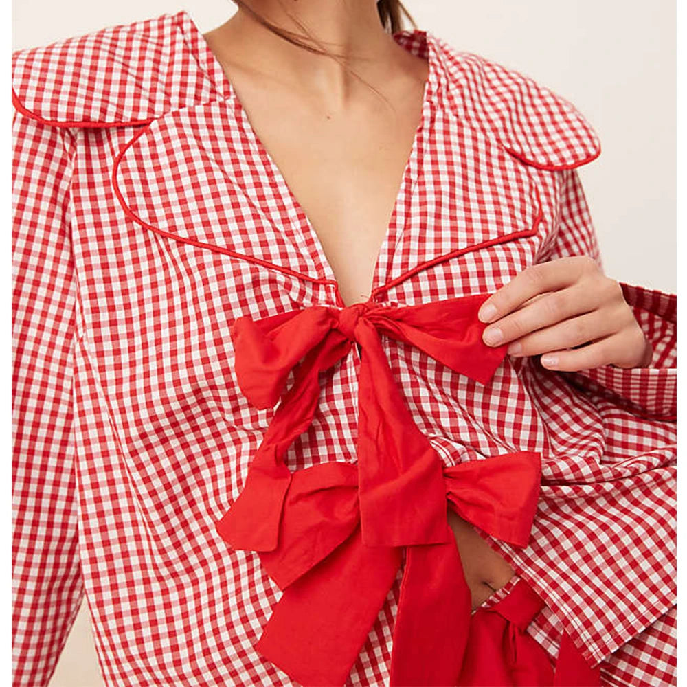 Red and white checkered dress with a large bow detail on a neutral background