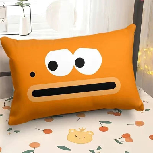 Orange pillow with a face design on a bed with a floral pattern
