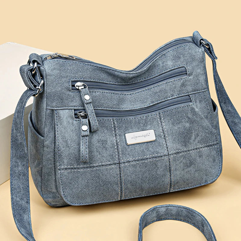 Women’s canvas crossbody shoulder bag with zip pockets and adjustable strap.