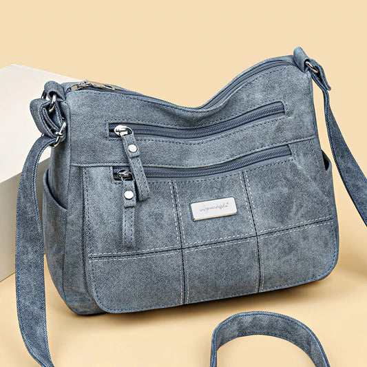 Women’s canvas crossbody shoulder bag with zip pockets and adjustable strap.