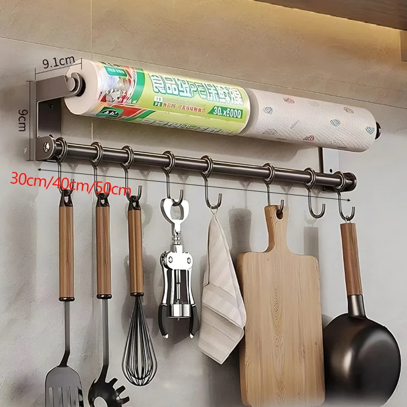 Wall-mounted kitchen organizer with utensils, cutting board, and paper towel holder.