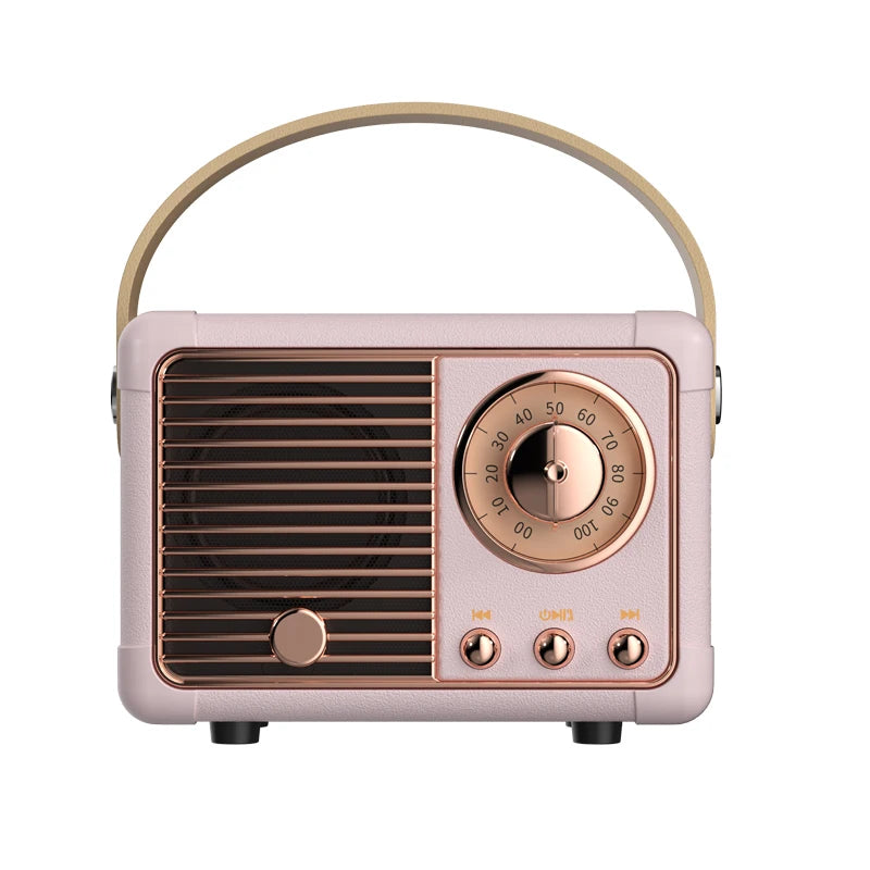 A retro-style portable radio with a pale pink body, rose gold control panel and handle, and dark brown front grille, shown on a plain white background.