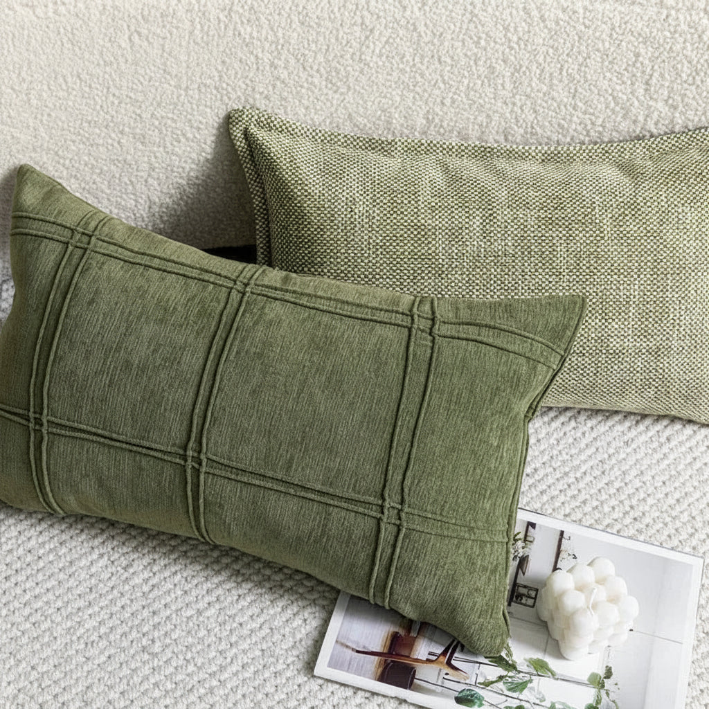 Two green pillows on a textured surface with a magazine underneath.