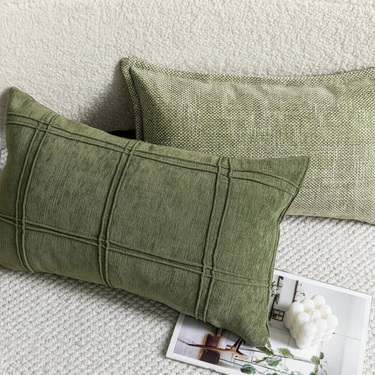 Two green pillows on a textured surface with a magazine underneath.