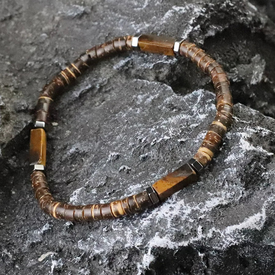 Beaded necklace with brown and silver beads on a textured stone surface