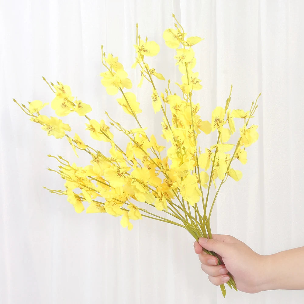 Hand holding a bouquet of yellow flowers against a white background