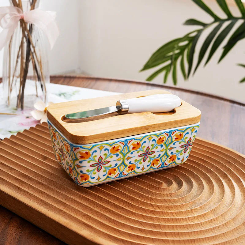 Decorative butter dish with floral pattern on a wooden surface