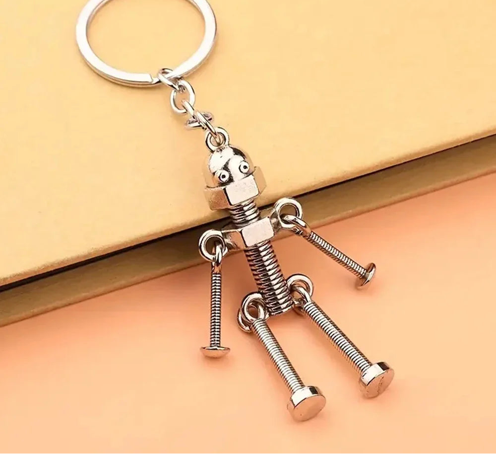 Metallic keychain shaped like a character made of nails on a beige background