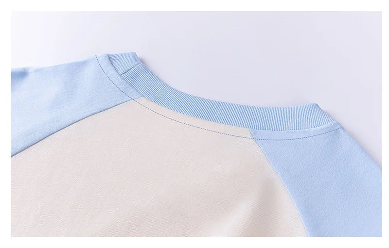 Close-up of a sweater with light blue and beige sleeves on a white background