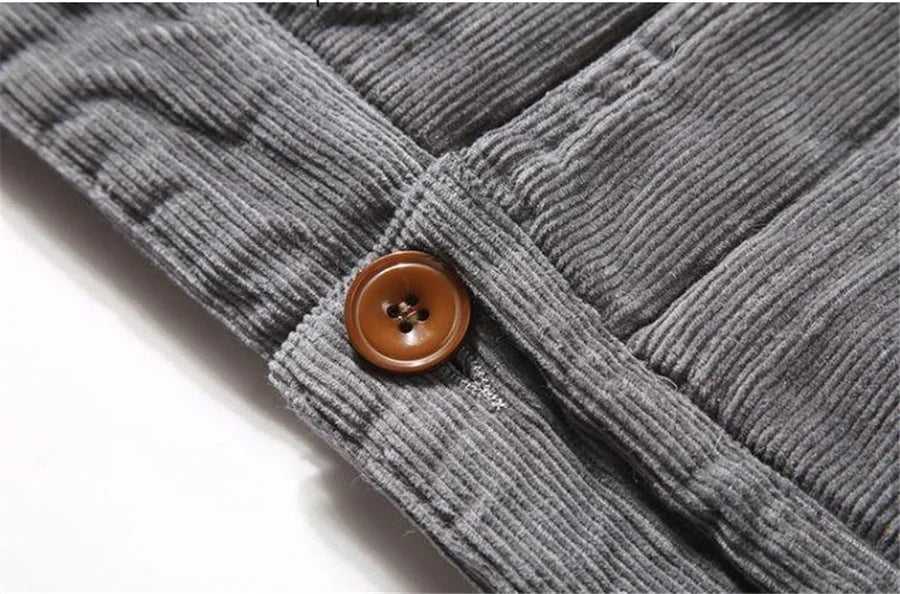Close-up of gray corduroy fabric with a brown button on a white background