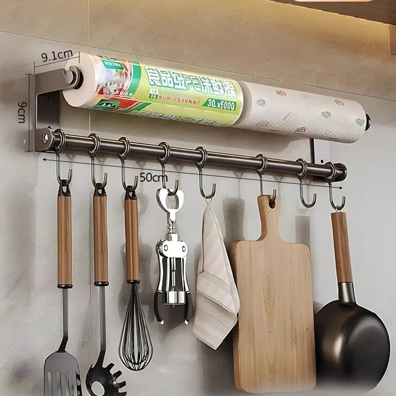 Kitchen wall organizer with hanging utensils, cutting board, and paper towels.