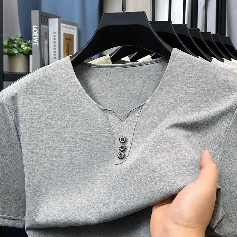 Gray henley shirt on a hanger with a blurred indoor background