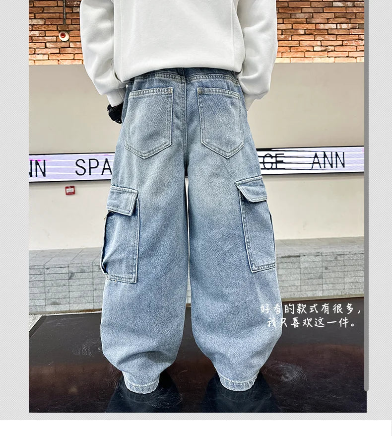Person wearing light blue cargo jeans with a brick wall background