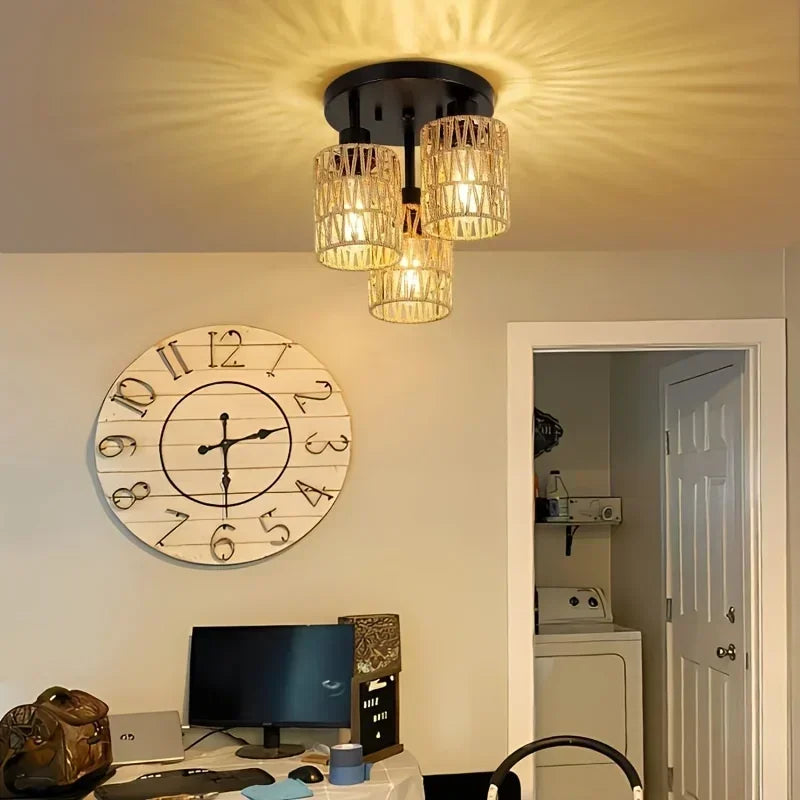 Ceiling light fixture in a room with a clock and computer setup.