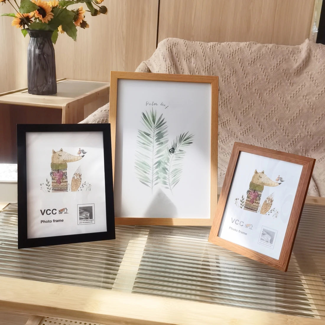 Three photo frames with different designs on a wooden surface.