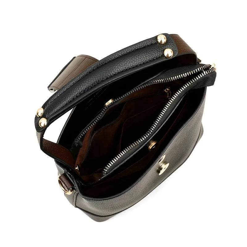 Black leather handbag with gold hardware on a white background