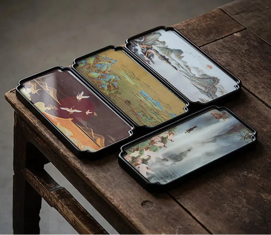 Rectangular bamboo tea tray with traditional landscape artwork displayed on a wooden surface