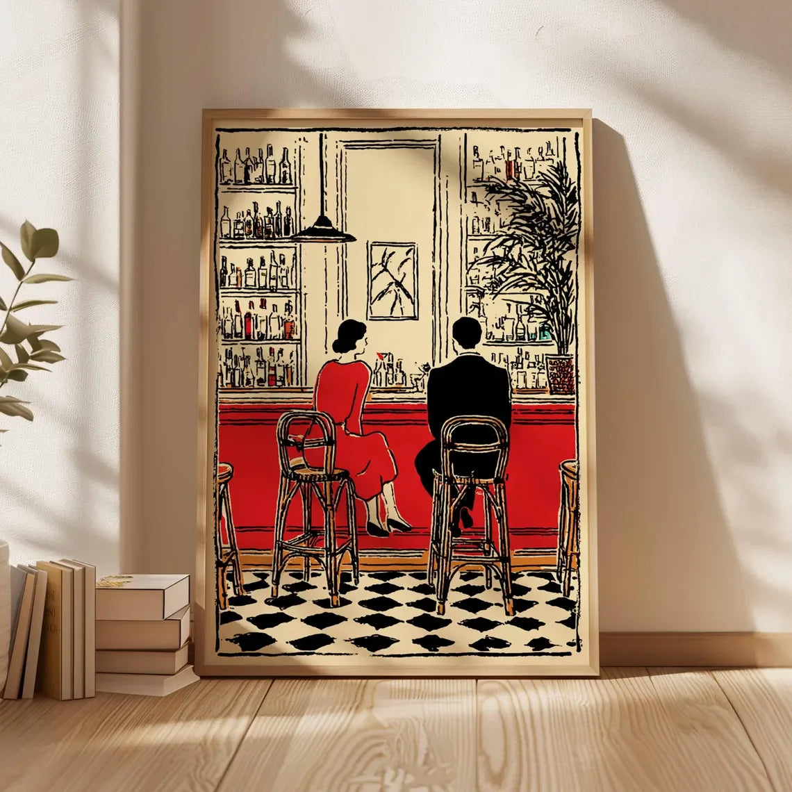 A framed art print depicting a vintage bar scene with two people seated at the counter, leaning against a wall on a wooden floor next to books and a plant.