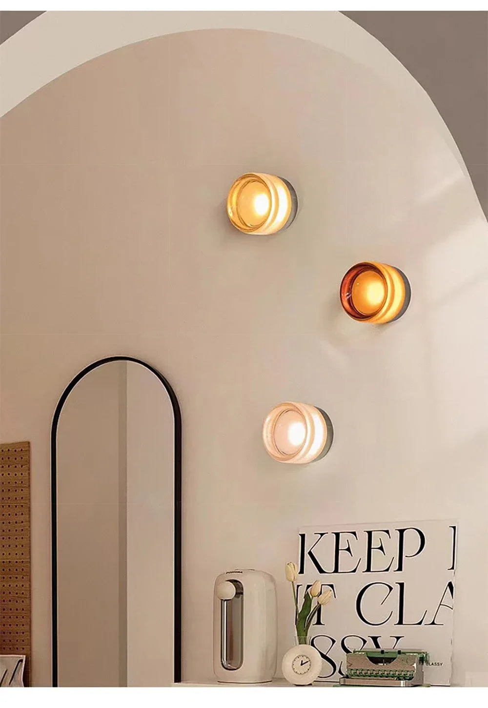 Decorative wall lights on a neutral wall with a mirror and decor items.