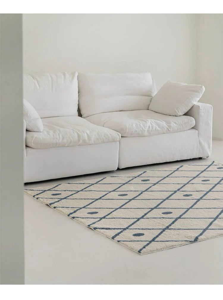 White sofa with a patterned rug in a minimalistic room