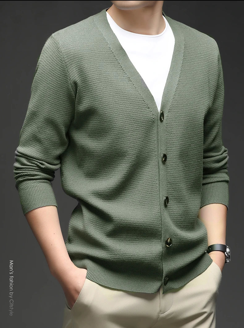 Green cardigan worn by a person on a dark background