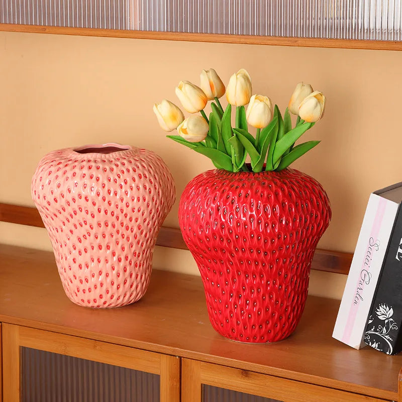 Two decorative vases with textured surfaces and flowers on a wooden surface.
