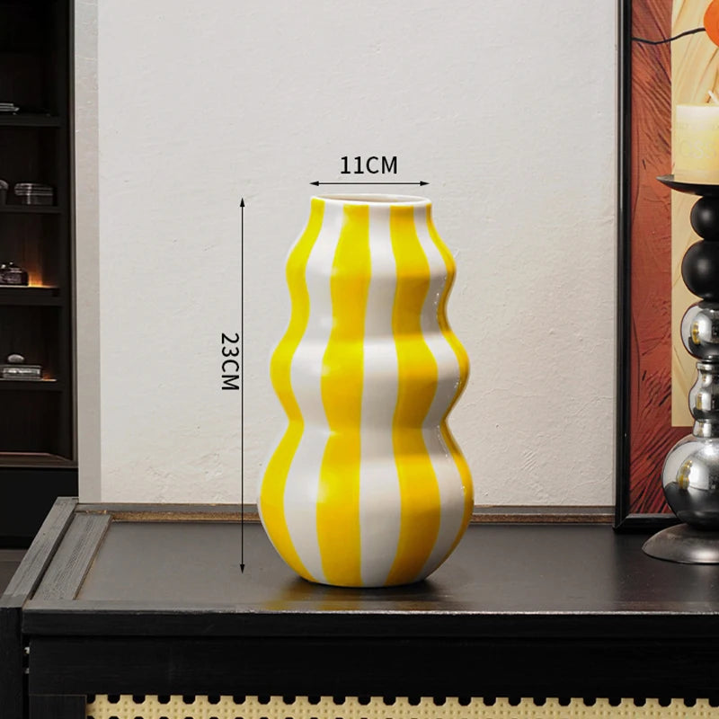 Yellow and white striped vase on a table with dimensions indicated