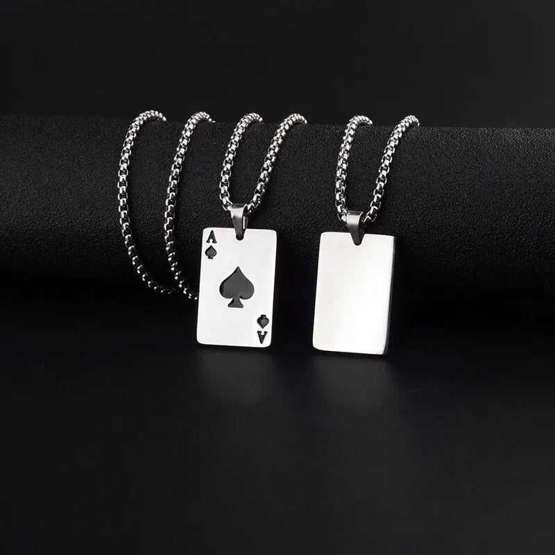 Two silver playing card ace of spades pendants on black background