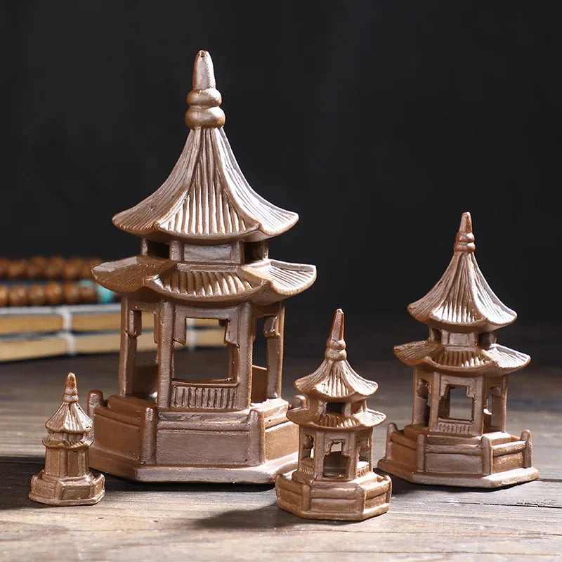 Set of miniature pagoda models on a wooden surface with a dark background