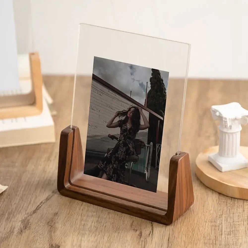 Clear acrylic photo stand with wooden base on a wooden surface