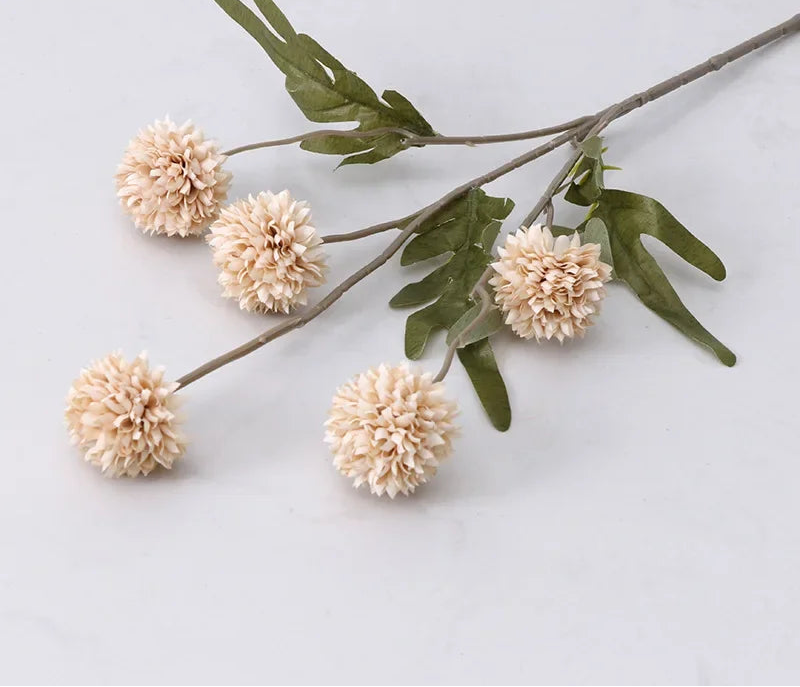 Branch with beige flowers and green leaves on a light gray background
