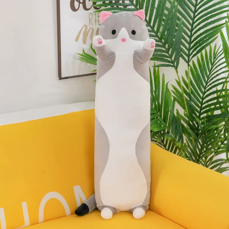 Cat-shaped plush pillow on a yellow couch with a plant in the background