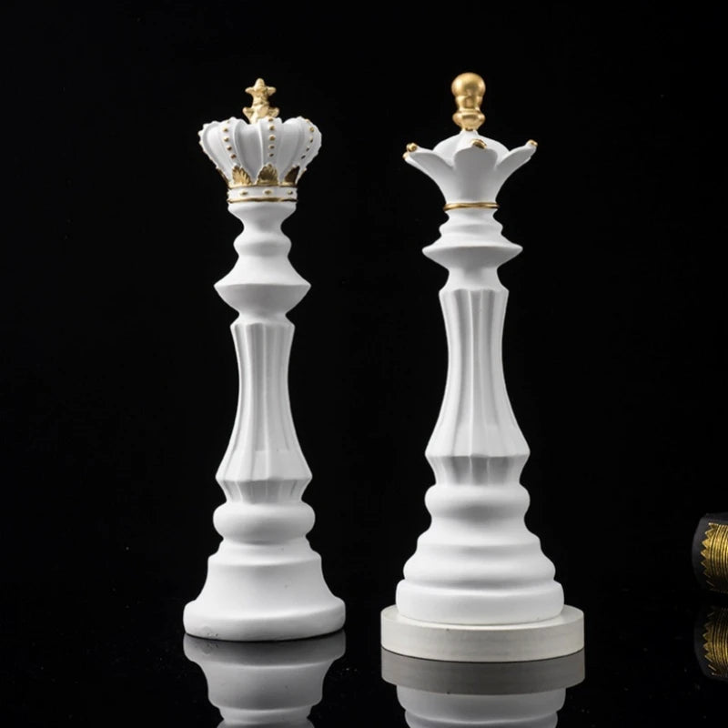 Two large white chess pieces with gold crowns on a black background